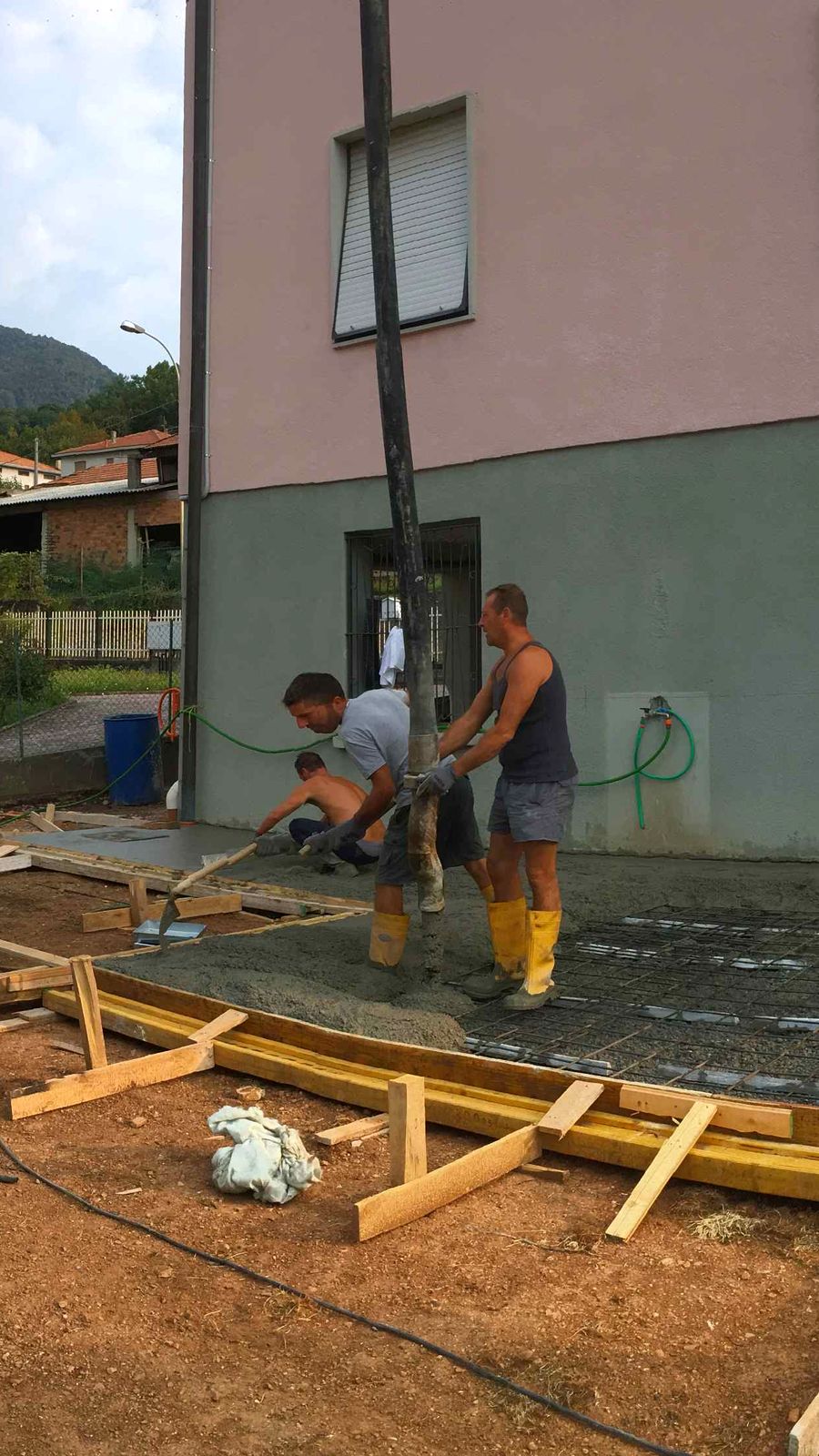 La nostra squadra stende il getto di cemento delle fondamenta davanti a una casa
